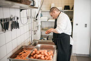 kantinen-5-15-portræt-køkkenmedarbejder-skræller-gulerødder